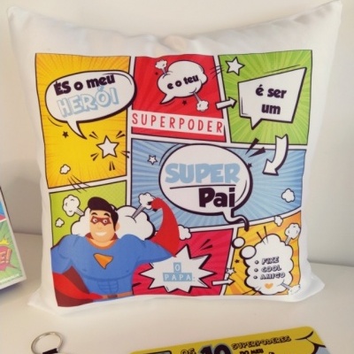 Almofada branca com estampado colorido estilo banda desenhada e frases em português sobre super pai