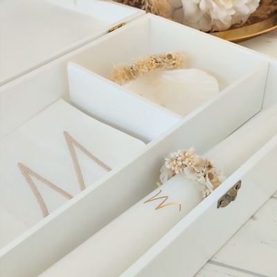 caixa branca com toalha, vela e flores secas decorativas