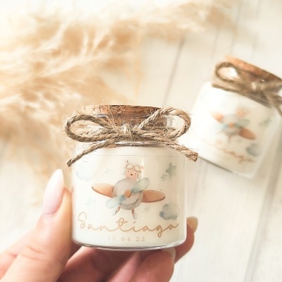 Frasco pequeno com tampa de cortiça, etiqueta com ursinho e avião, texto Santiago 15.04.23