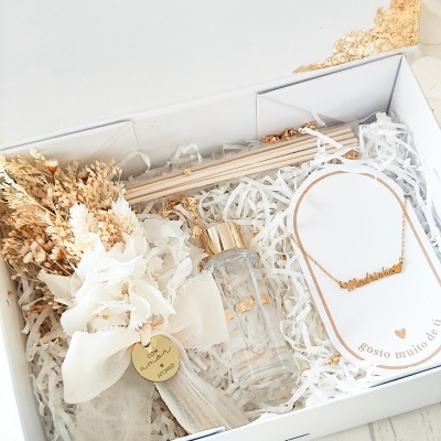 Conjunto de presente com flores secas, colar dourado e frasco decorativo em caixa branca