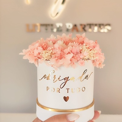 Vaso branco com flores cor de rosa e texto dourado 'obrigada POR TUDO'