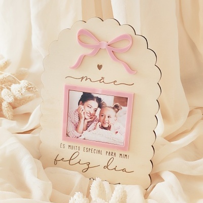 Moldura de madeira clara em forma de nuvem com laço rosa e foto de mãe e filha