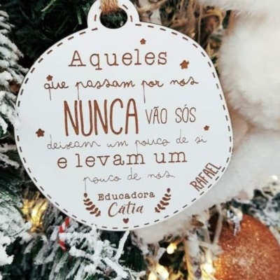 Ornamento de árvore de Natal branco com texto em português pendurado numa árvore de Natal