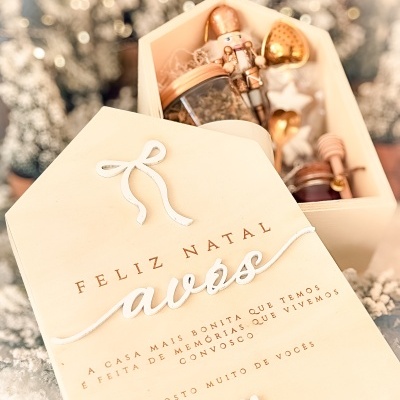 Caixa de presente de madeira clara com decoração natalícia, incluindo soldadinho de chumbo dourado e frascos com tampa dourada