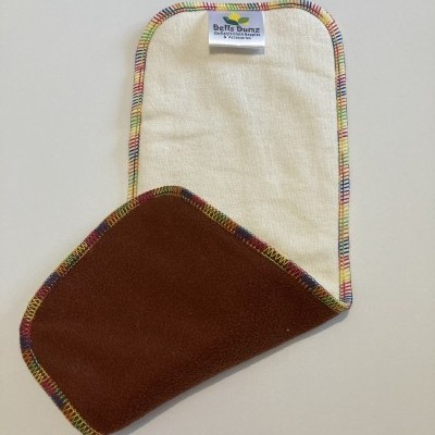 Toalhete de tecido bege e castanho com bordas coloridas e etiqueta