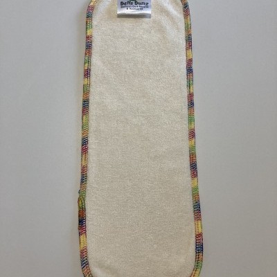 Fralda de pano branca com bordas multicoloridas e etiqueta visível