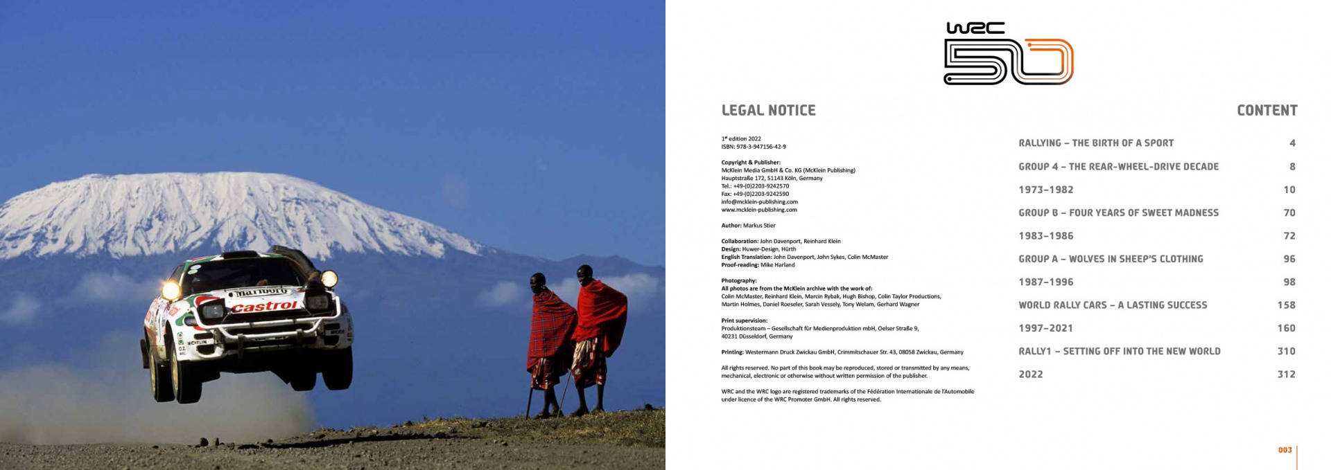 WRC 50 - The Story of the World Rally Championship 1973-2022 Carro de rali a saltar em estrada de terra com montanha nevada ao fundo e duas pessoas observando