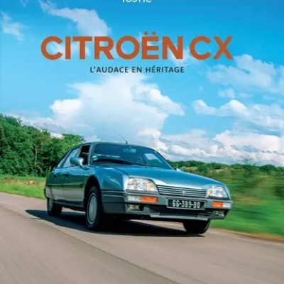 Carro Citroën CX azul em estrada com vegetação e céu azul