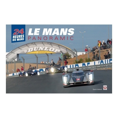 Carros de corrida no circuito Le Mans com estrutura Dunlop ao fundo