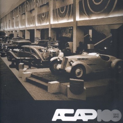 Salão de exposição com carros clássicos e texto comemorativo