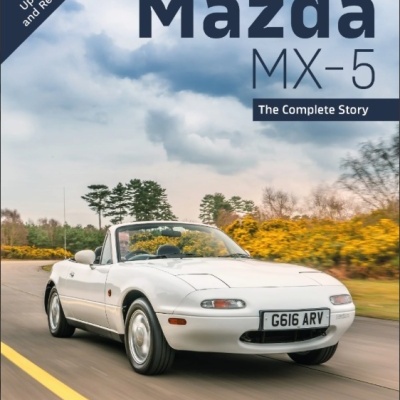 Livro sobre Mazda MX-5 com capa a mostrar carro branco descapotável em estrada