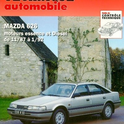 Revista técnica automóvel com Mazda 626 cinza em rua junto a paredes de pedra.