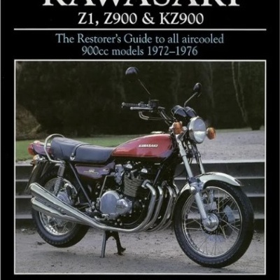 Livro sobre motocicleta Kawasaki clássica vermelha e preta em piso de cimento.