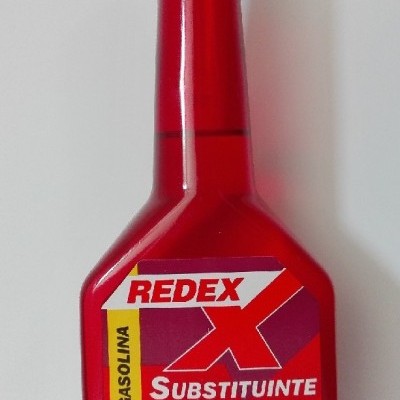 Frasco vermelho de aditivo para gasolina REDEX com texto em português.