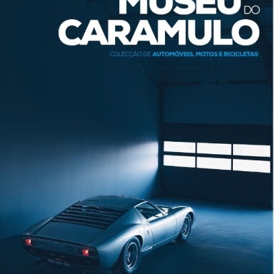 Carro desportivo clássico prateado numa garagem escura com luz natural