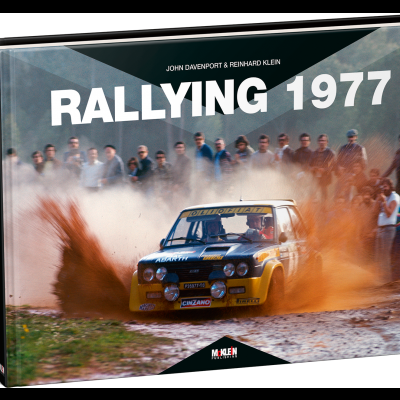 Livro com capa ilustrada de carro de rali amarelo e azul em estrada de terra com pessoas ao fundo, título Rallying 1977
