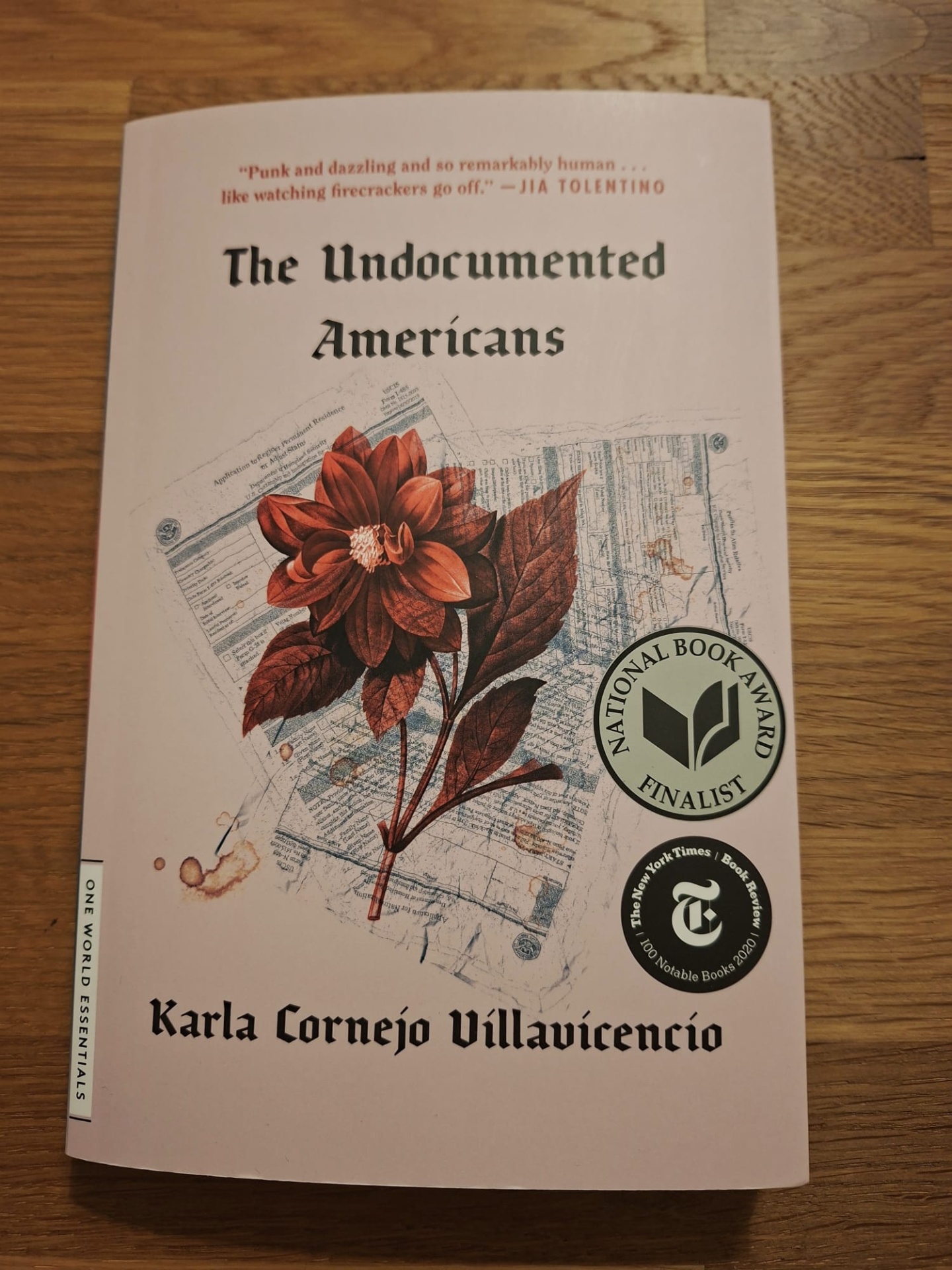 The Undocumented Americans, Karla Cornejo Villavicencio Capa do livro The Undocumented Americans com flor vermelha e selos de prémios em fundo branco.