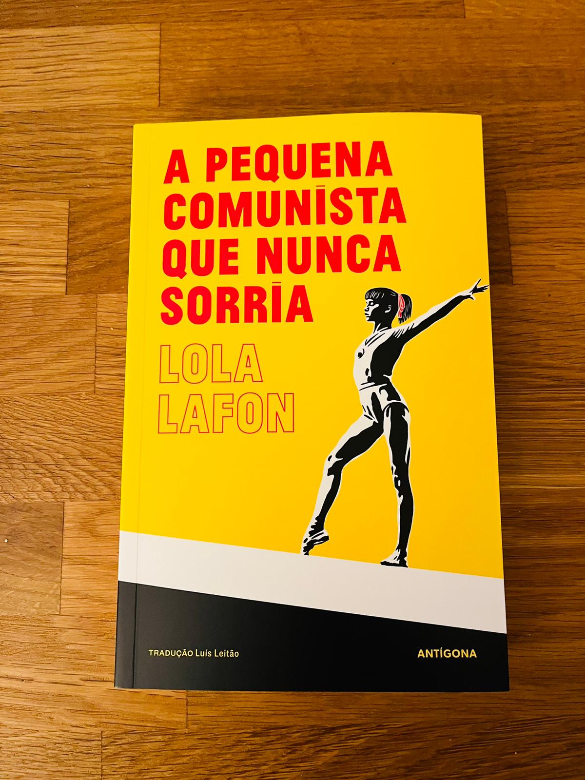 A Pequena Comunista que Nunca Sorria, de Lola Lafon Livro amarelo e preto com ilustração feminina e título em letras vermelhas e amarelas