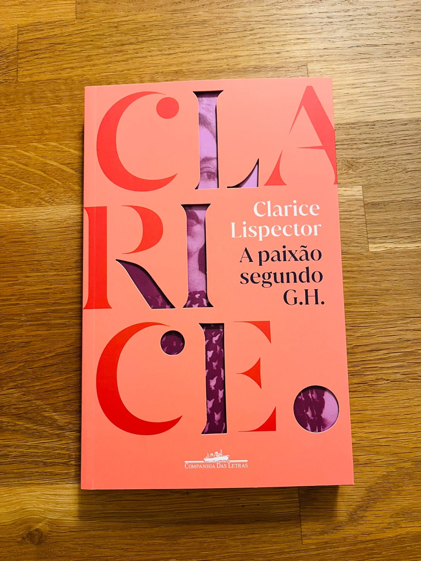 A paixão segundo G.H., de Clarice Lispector Livro com capa rosa com letras vermelhas e recortes mostrando padrão roxo, título Clarice Lispector A paixão segundo G.H.