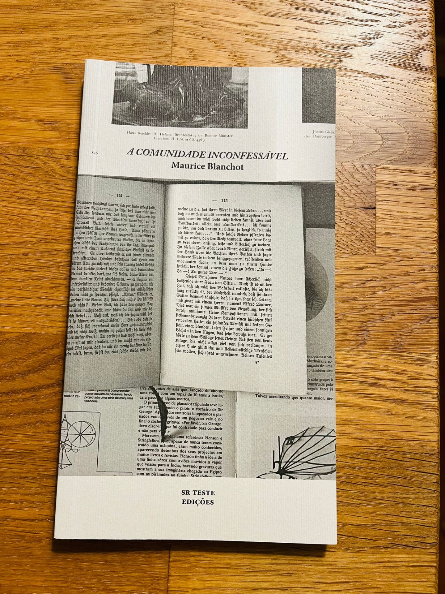 A Comunidade Inconfessável, de Maurice Blanchot Capa de livro 'A Comunidade Inconfessável' de Maurice Blanchot com design de páginas em preto e branco e fundo madeira