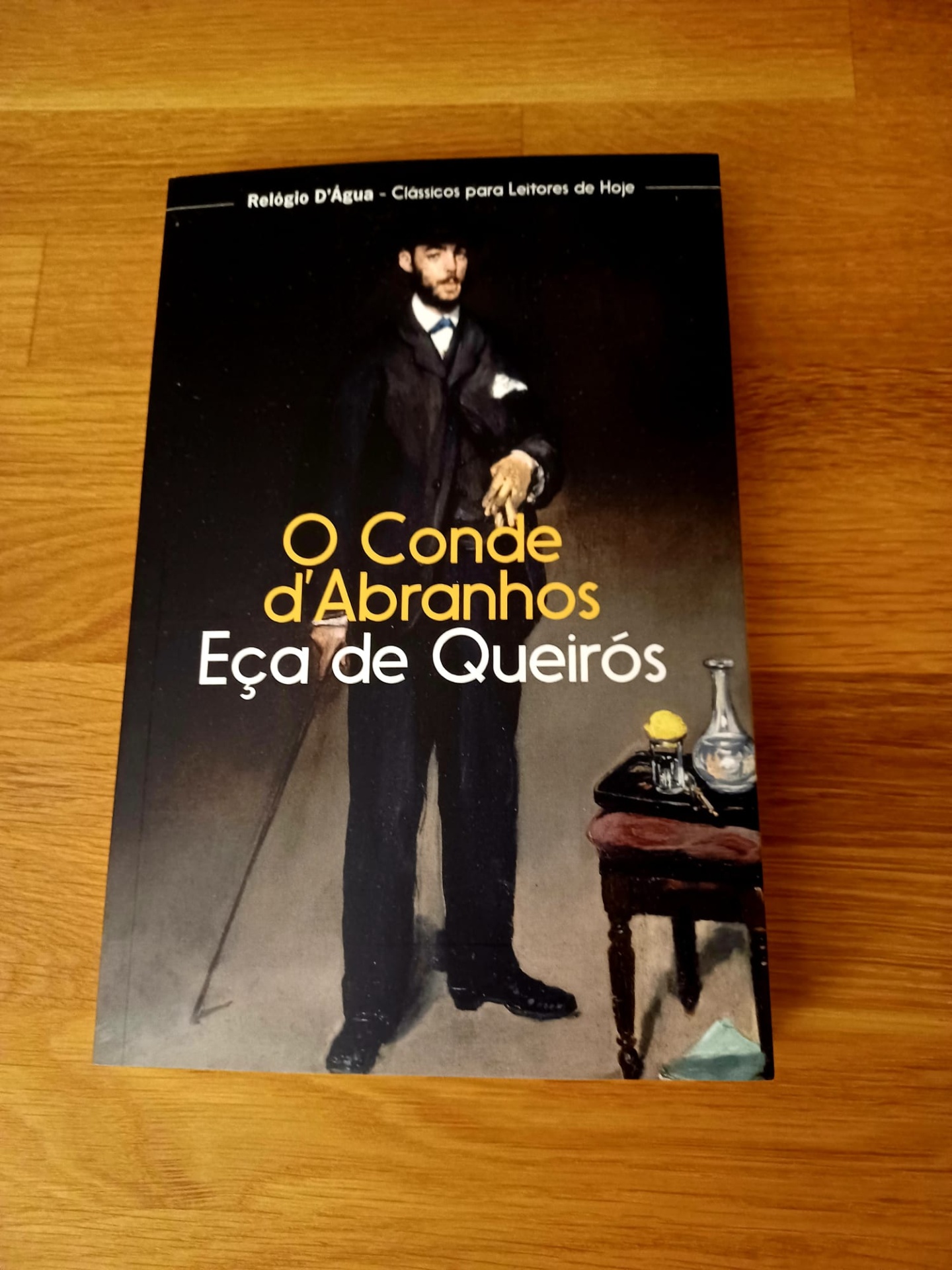 O Conde d’Abranhos, de Eça de Queiroz Livro 'O Conde d'Abranhos' de Eça de Queirós com capa preta e imagem de homem vestido de fato escuro