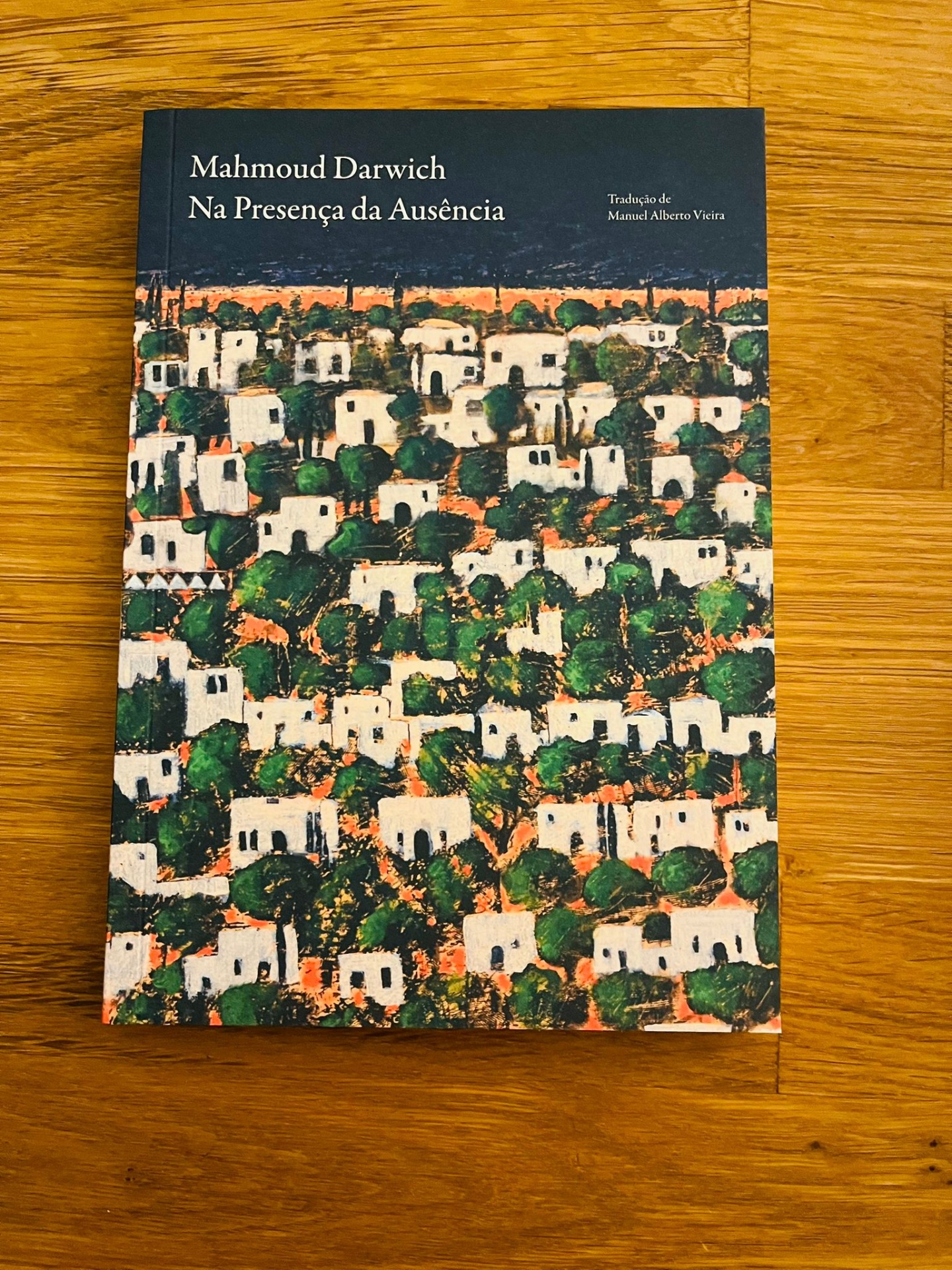 Na Presença da Ausência, de Mahmoud Darwich Livro 'Na Presença da Ausência' de Mahmoud Darwich sobre superfície de madeira.
