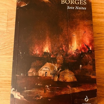 Capa do livro 'Sete Noites' de Jorge Luis Borges com ilustração de vila em chamas em tons castanho e laranja