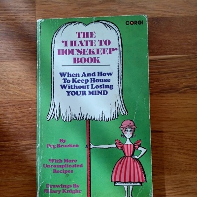 Livro verde com título e ilustração de mulher em vestido vermelho e branco