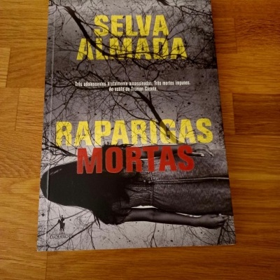 Livro 'SELVA ALMADA RAPARIGAS MORTAS' com capa cinzenta e figura de costas vestindo calças de ganga