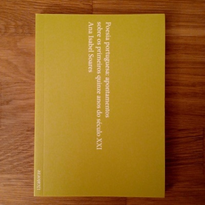 Livro amarelo esverdeado com texto branco sobre madeira