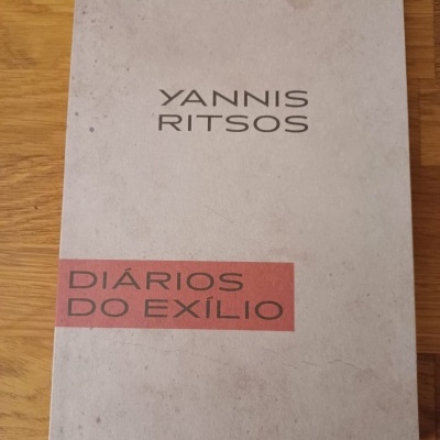 Capa de livro clara com texto YANNIS RITSOS e DIÁRIOS DO EXÍLIO em faixa vermelha