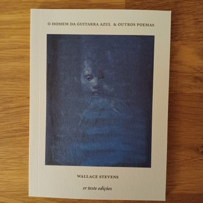 Livro com capa creme com imagem azul e texto em português