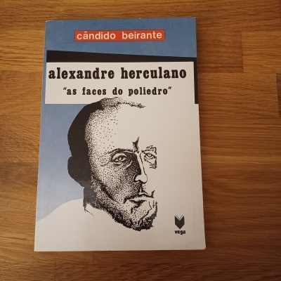 Capa de livro com título alexandre herculano e autor cândido beirante sobre mesa de madeira