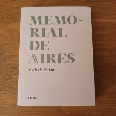 Capa do livro 'MEMORIAL DE AIRES' de Machado de Assis sobre mesa de madeira