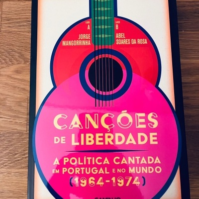 Capa de livro com ilustração de guitarra e texto sobre canções de liberdade.