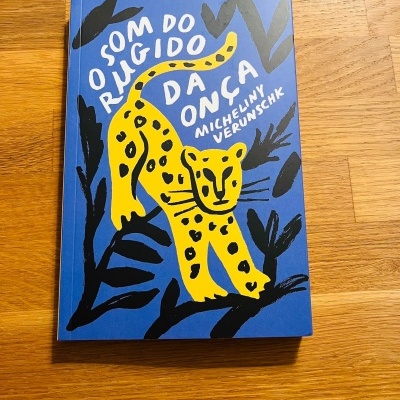 Livro azul com onça amarela e texto em branco