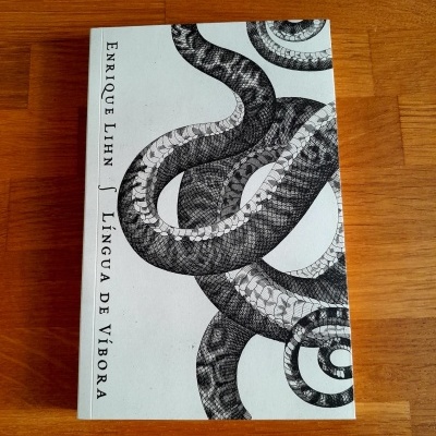 Livro com capa branca com ilustração de cobra e texto ENRIQUE LIHN LÍNGUA DE VÍBORA