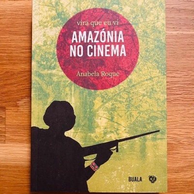 Livro 'AMAZÓNIA NO CINEMA' de Anabela Roque com silhueta a segurar rifle e fundo verde