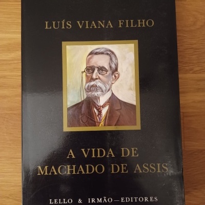 Capa de livro preta com texto dourado e retrato antigo de homem