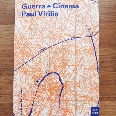Capa de livro com mapa topográfico laranja e azul e texto azul 'Guerra e Cinema Paul Virilio'