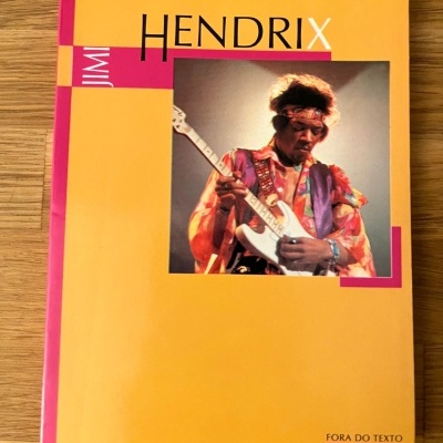 Livro amarelo com imagem de Jimi Hendrix a tocar guitarra e texto na capa.