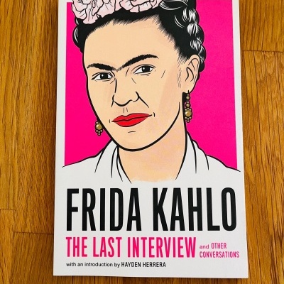 Capa do livro de Frida Kahlo com fundo rosa e ilustração da artista
