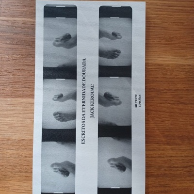 Livro com capa branca e pés em fotos em preto e branco