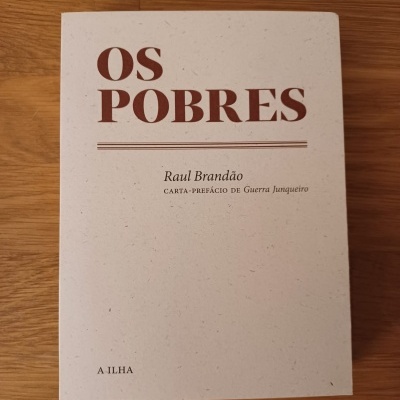 Capa de livro branco 'OS POBRES' de Raul Brandão sobre madeira