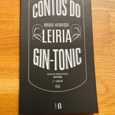 Livro preto 'Contos do Gin-Tonic' de Mário-Henrique Leiria sobre mesa de madeira
