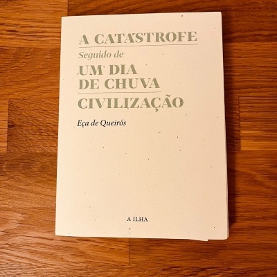 Livro 'A CATASTROFE Seguido de UM DIA DE CHUVA CIVILIZAÇÃO' sobre mesa de madeira