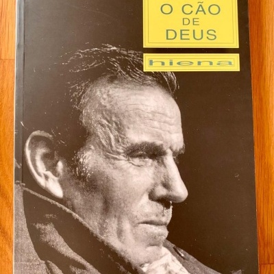 Capa de livro preto com fotografia em preto e branco de homem e texto em amarelo