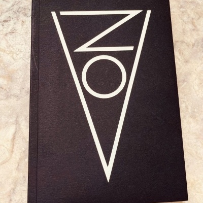 Livro preto com letras brancas e triângulo invertido