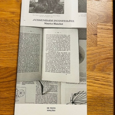 Capa de livro 'A Comunidade Inconfessável' de Maurice Blanchot com design de páginas em preto e branco e fundo madeira