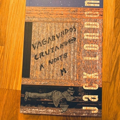 Capa de livro com ilustração de madeira envelhecida e texto 'VAGABUNDOS CRUZANDO A NORTE'